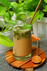 a glass of iced coffee with green grass jelly 