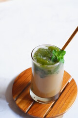 a glass of iced coffee with green grass jelly 