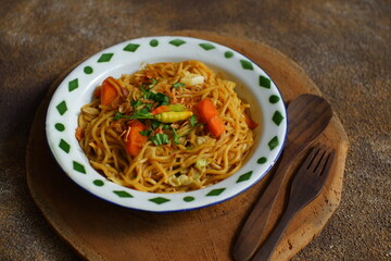 a plate of noodles cooked in sauce with vegetables 