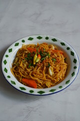 a plate of noodles cooked in sauce with vegetables 