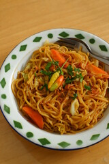 a plate of noodles cooked in sauce with vegetables 
