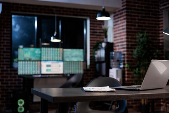 Interior of empty forex stock market workspace with desk having modern laptop computer on top. Exchange company office with nobody in it and multiple monitors workstation.
