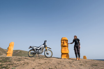 Female traveling on dirt bike motorcycle wearing protection  moto armor jacket standing near the...