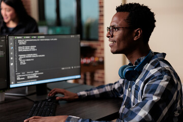 Fototapeta na wymiar Smiling confident african american software engineer developing machine learning algorithm in order to sustain system security stability. Cyber developer creating network using binary encryption.