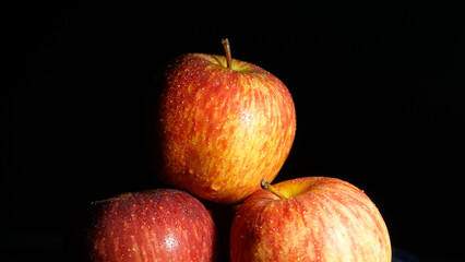 Picture of three red apples taken from the studio at night using artificial light