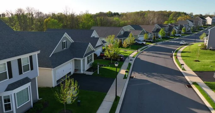 Golden hour light of homes in American neighborhood in USA. Spring trees bloom.