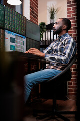 Forex trading agent sitting at desk with multi monitor workstation while visualizing real time financial data on screens. Hedge fund company agent trying to foretell bear market period using charts.