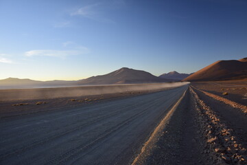 Sandy road through the desert at sunrise in Eduardo Avaroa National Reserve in Uyuni, Bolivia.
