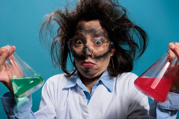 Confused silly chemistry expert holding glass jars filled with toxic chemical liquid substances...