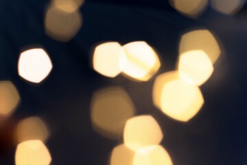 blurred golden lights of a New Year's garland on a dark background, light blur