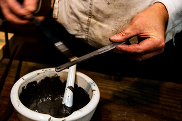 Fototapeta na wymiar Applying mud onto a small katana before forging.