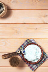 Shaving razor, brush, gel and electric trimmer on the wooden table. Vertical template with hygiene tools and copy space