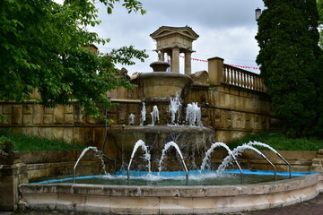 fountain in the old park on a cloudy spring day