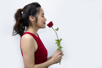 Asian beautiful women are smelling red rose and closing eyes  with happiness and smile. A Valentine day and Love