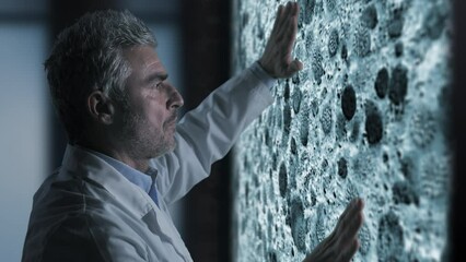 scientist biologist doctor using touchscreen graphic interface analyzes studies virus cells moving on the screen,animation graphic - Powered by Adobe