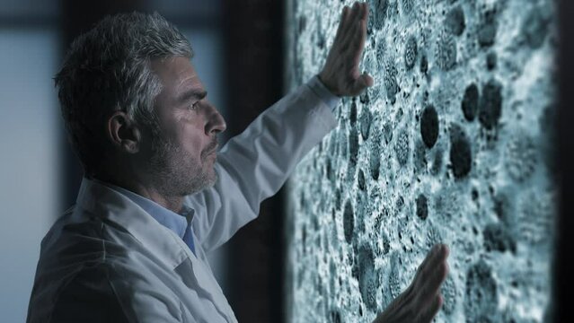 scientist biologist doctor using touchscreen graphic interface analyzes studies virus cells moving on the screen,animation graphic