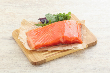 Raw salmon fillet over board