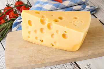 Maasdam cheese piece over board