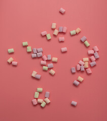 Multicolored candies on a pink background. Close-up