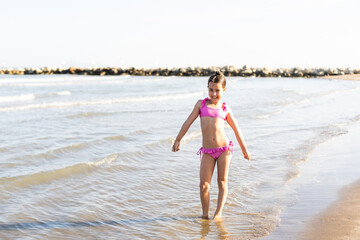 Adorable little girl have fun on tropical white sandy beach