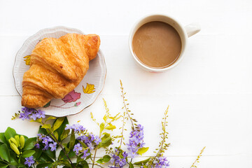croissant dessert snack on paper with hot tea arrangement flat lay style on background white