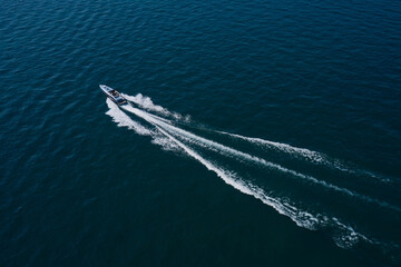 Boat performance movement on the water aerial view. High-speed luxury boat driving on dark blue...