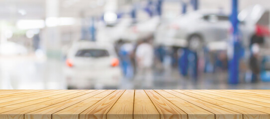 Empty wood table top with car service centre auto repair workshop blurred background