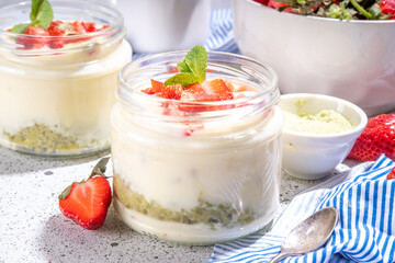 Sweet matcha strawberry dessert. Breakfast layered parfait dessert with yogurt, matcha green tea sponge biscuit and fresh strawberry, white background copy space