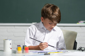 Child boy drawing with coloring pens, painting with early development paints. Childhood learning, kids artistics skills.