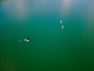 Fototapeta na wymiar overhead view of people on paddle boards in the middle of the lake