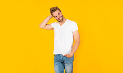 smiling unshaven young man in white shirt on yellow background, mens beauty