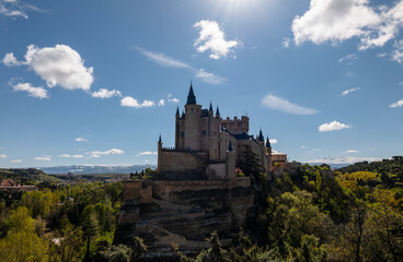 Castle of Segovia surrounding by trees against clear sky. Segovia, Spain