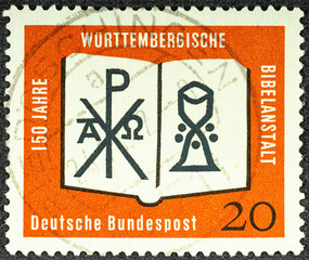 GERMANY - CIRCA 1962: a postage stamp printed in Germany showing an open Bible with a monogram of...