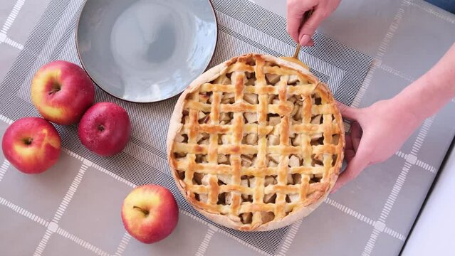 Apple pice cake preparation series - woman taking slicie of a traditional pie - top view