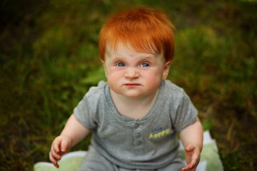Little red-haired boy looks at the sky