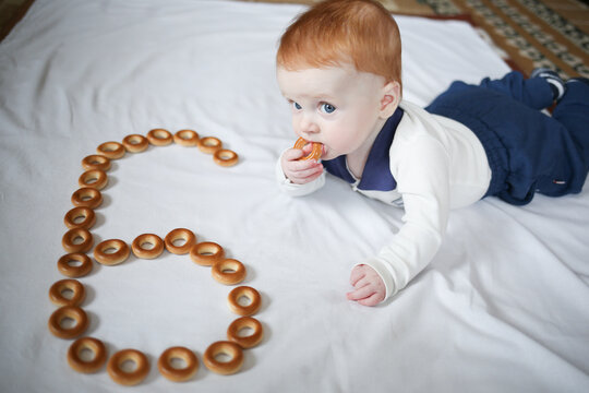 A Little Boy Of 6 Months Eats Bagels