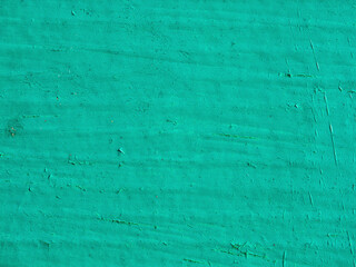 Abstract background of bright green plaster on the wall. Turquoise painted wall texture background, design template. Green grunge texture