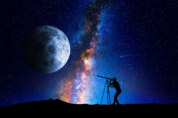 Man looking at the stars and moon through a telescope