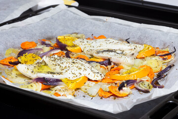 White fish papillote with vegetables, extra virgin olive oil, orange and dill, on baking paper