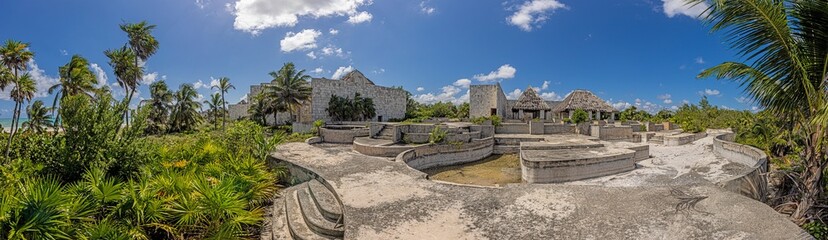 Picture of a destroyed, overgrown and left to itself hotel complex on a beach