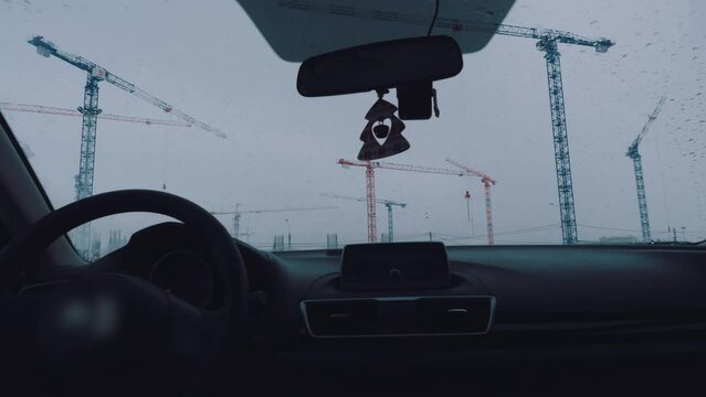 Accelerated shooting of tower cranes from a car, timelapse of construction cranes