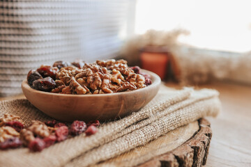 Nuts, dates and cranberries in a wooden plate, top view