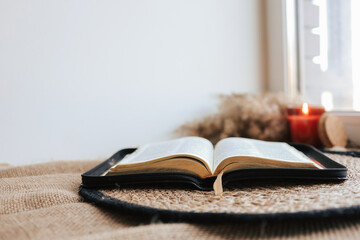 Open Holy Bible on a old wooden table and white wall background. Religion concept. Cozy warm photo