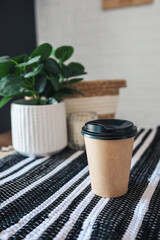 Paper cup of coffee on cafe table in scandinavian style