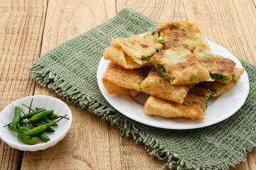 Martabak, Martabak Telor or Martabak Telur. Savory pan-fried pastry stuffed with egg, meat and spices. Martabak Telur is one of Indonesia street food. Served on white plate.
