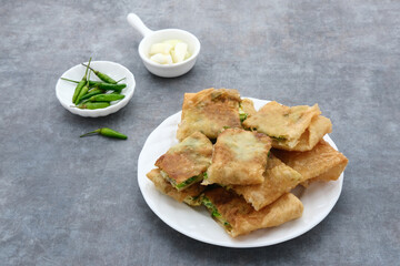Martabak, Martabak Telor or Martabak Telur. Savory pan-fried pastry stuffed with egg, meat and spices. Martabak Telur is one of Indonesia street food. Served on white plate.
