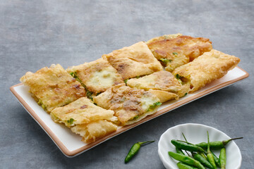Martabak, Martabak Telor or Martabak Telur. Savory pan-fried pastry stuffed with egg, meat and spices. Martabak Telur is one of Indonesia street food. Served on white plate.
