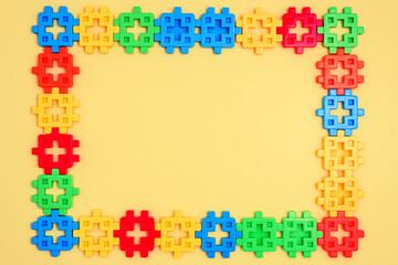 Colorful kids toys frame on yellow background. Top view. Flat lay. Copy space for text. Concept World Children's Day