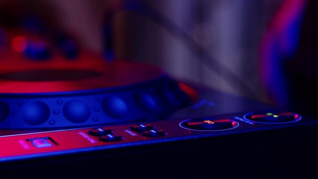 Closeup digital mixing console and hands adjusting fader. Male hands professional DJ press buttons cue and play twice. Concept modern musical accompaniment of event and work of professional