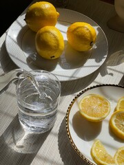 lemons on the plates, glass of water, flat lay lemonade, breakfast ideas 